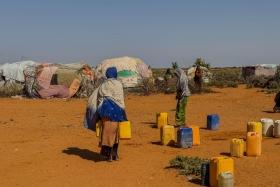  Au point de distribution d'eau du camp de déplacés de Rasqabobe, dans la région de Mudug, en Somalie, les habitants remplissent des jerrycans.