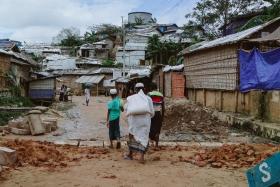 Des personnes marchant le long d'une route principale dans les camps. 