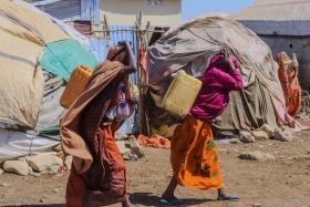 Des femmes transportent des bidons alors qu'elles reviennent du point de distribution d'eau du camp de personnes déplacées de Banban, à Baidoa, en Somalie.