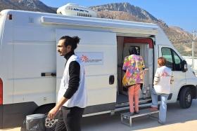 Un agent de santé MSF, accompagne le patient jusqu’à la clinique mobile afin de faciliter la traduction pendant la consultation médicale, Grèce, octobre 2025.
