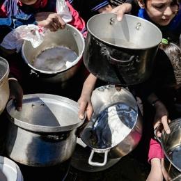 Des enfants tenant leurs pots vides dans une cuisine communautaire dans le nord de Gaza, février 2025 