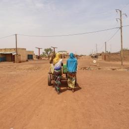 Centre-ville de Djibo - deux femmes poussant une charrette d'eau.