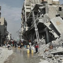 Des habitants vont chercher de l'eau près d'un bâtiment menaçant de s'effondrer à Beit Lahia, dans le nord de la bande de Gaza, le 3 février 2025