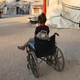 Une enfant près d'un fauteuil roulant qu'elle utilise pour transporter des jerricans d'eau, dans la ville de Gaza, en raison de la destruction systématique des infrastructures hydrauliques par Israël.
