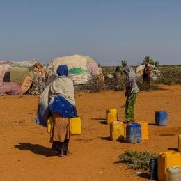  Au point de distribution d'eau du camp de déplacés de Rasqabobe, dans la région de Mudug, en Somalie, les habitants remplissent des jerrycans.