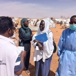 Un membre du personnel de MSF discute avec une femme à Al Mina Al Muwahad, le plus grand camp de déplacés près de la ville d'El Obeid.