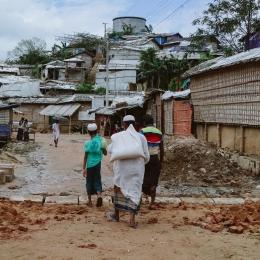 Des personnes marchant le long d'une route principale dans les camps. 