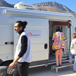 Un agent de santé MSF, accompagne le patient jusqu’à la clinique mobile afin de faciliter la traduction pendant la consultation médicale, Grèce, octobre 2025.