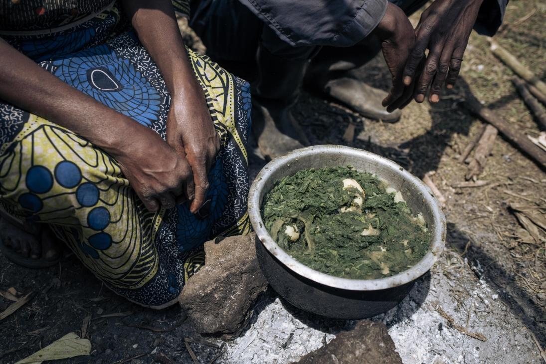 Ponsie et sa femme, assis devant un plat de feuilles bouillies, la seule nourriture qu'ils ont réussi à trouver autour de l'école primaire de Rumangabo.