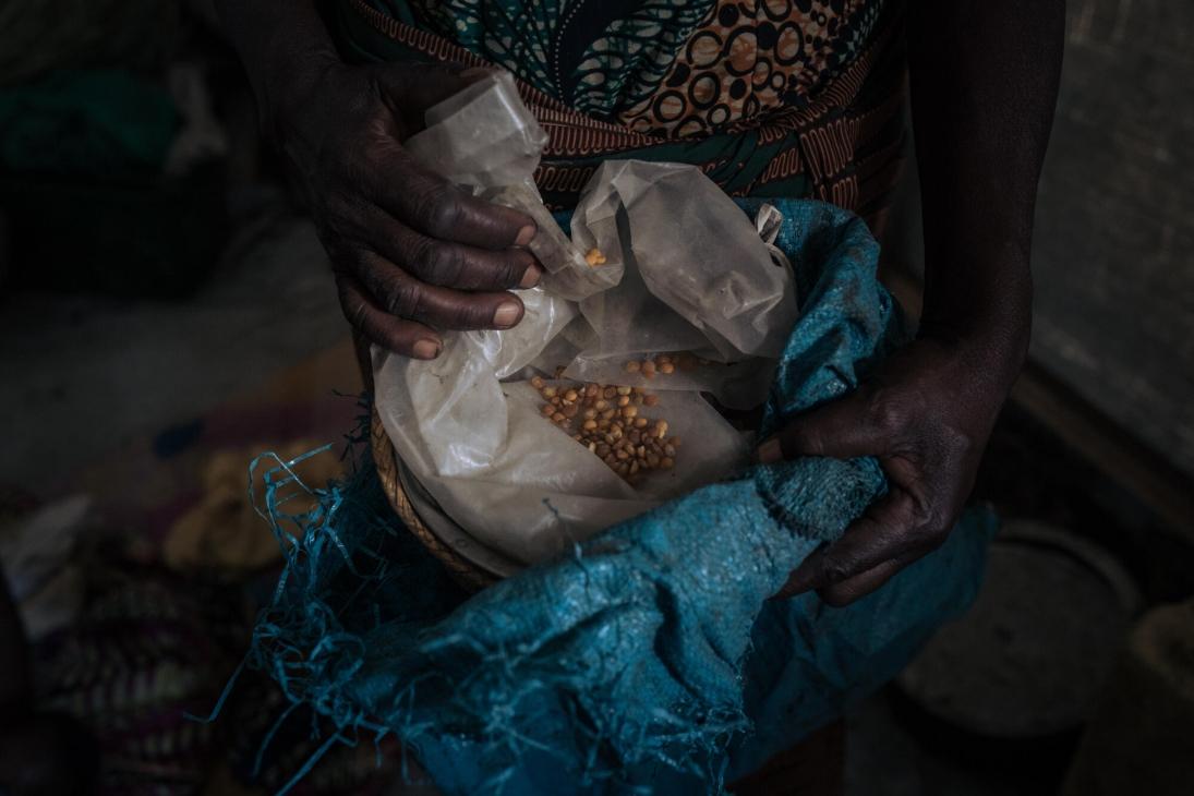 Agrippine tient les derniers grains de maïs qu'il lui reste pour nourrir sa famille. 