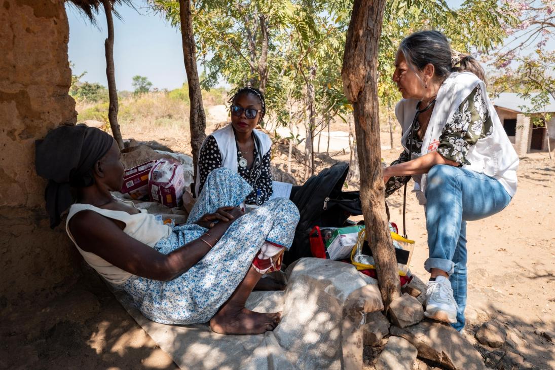 Une patient soutenue par MSF assise devant sa maison dans son village au Malawi