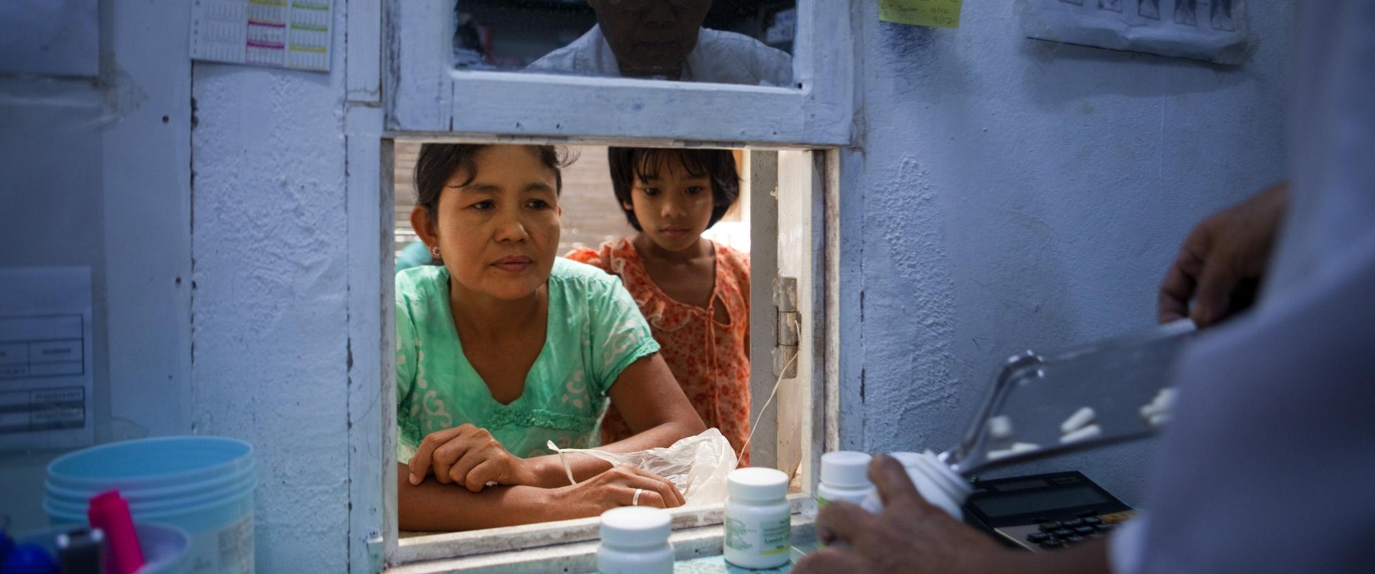 Une grand-mère prend les ARV de ses petites-filles à la pharmacie de Dawei, au Myanmar. N'étant n'est pas en mesure de se déplacer fréquemment, elle doit prendre suffisamment de traitement pour deux mois.