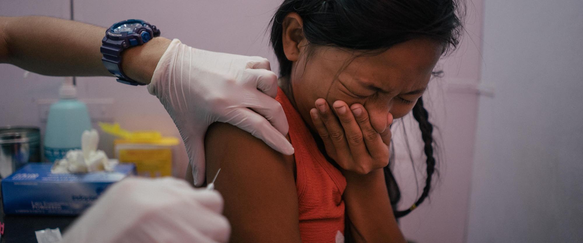 Une jeune fille de Tondo, Manille, est vaccinée gratuitement contre le papillomavirus dans la clinique de Likhaan/MSF. 