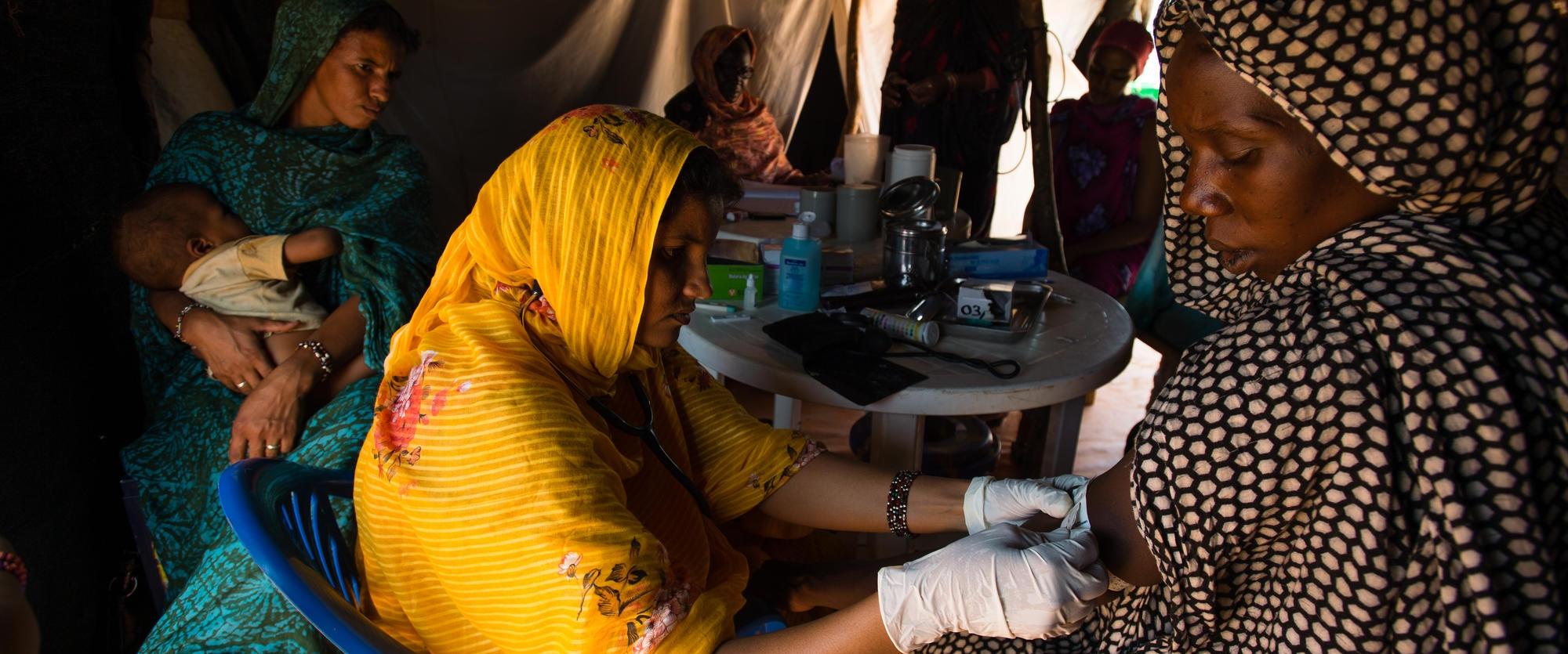 Prise de la tension artérielle d'une patiente dans la tente de maternité de l'hôpital de Médecins Sans Frontières dans le camp de réfugiés maliens de Mbera, en Mauritanie en mars 2013.