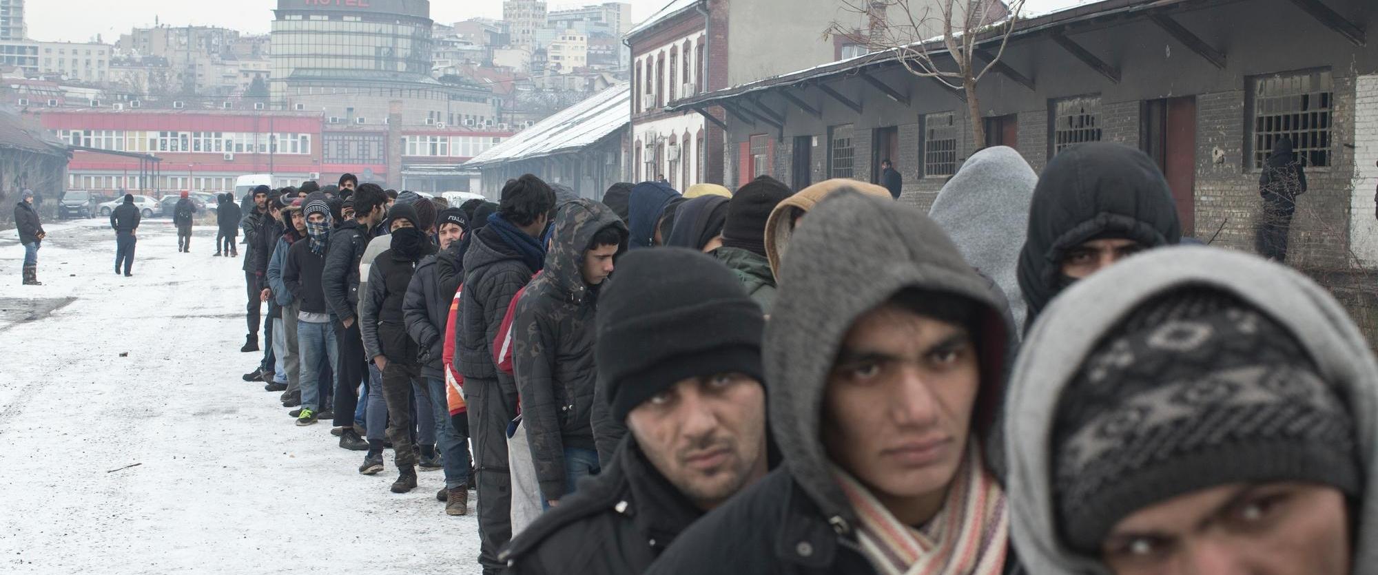 Des réfugiés font la queue pour obtenir de la nourriture dans un entrepôt abandonné utilisé comme abri à Belgrade, en Serbie, en janvier 2017.