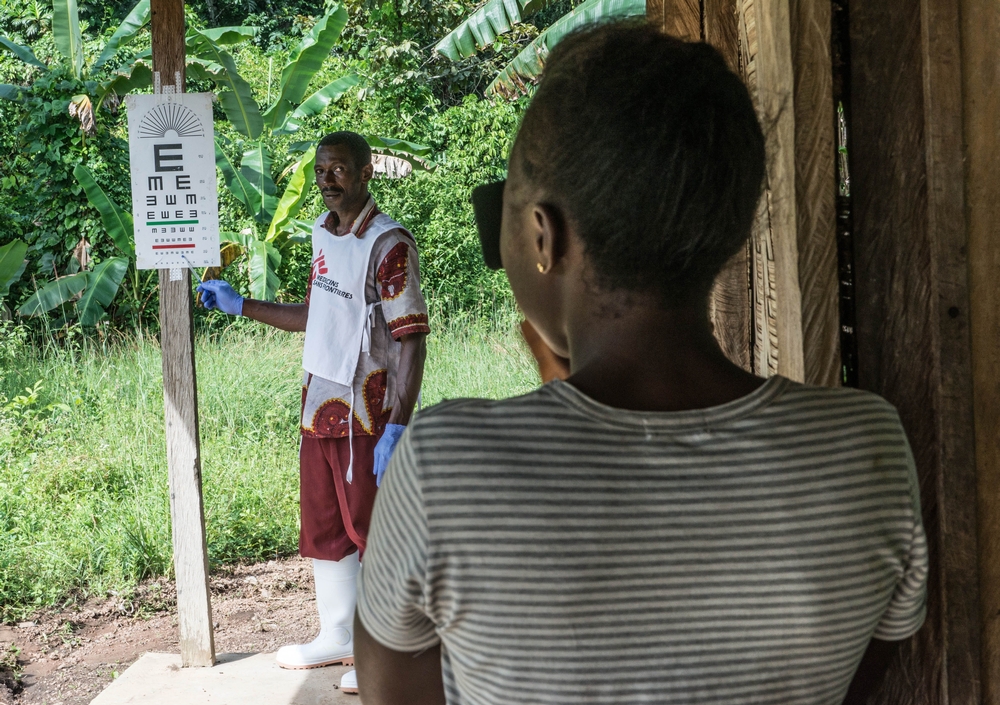 Joseph, promoteur de la santé, fait passer un test ophtalmologique à une survivante d’Ebola durant une consultation de surveillance à Mabekoh, en Sierra Leone. © Tommy Trenchard 2015
